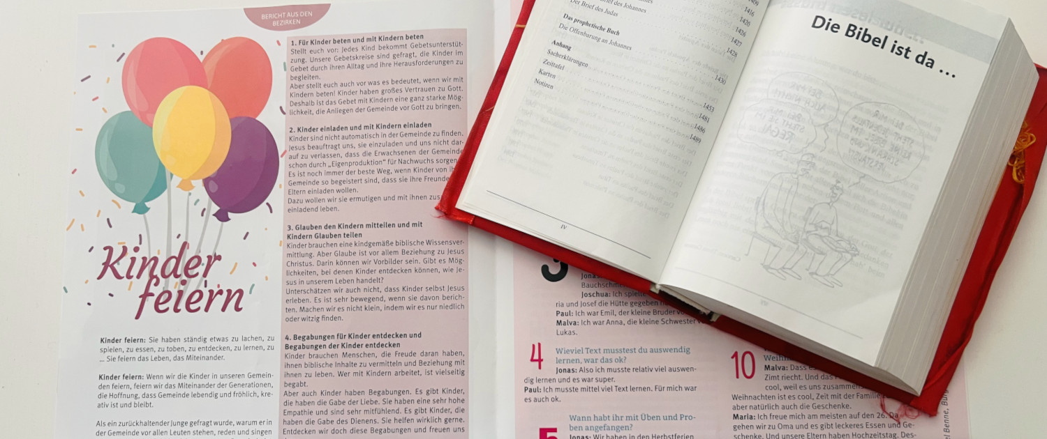 Es ist im Hintergrund eine geöffnete Ausgabe des Heftes "Gemeinschaft leben" zu sehen, darüber liegt quer eine Bibel, die ebenfalls aufgeschlagen ist.